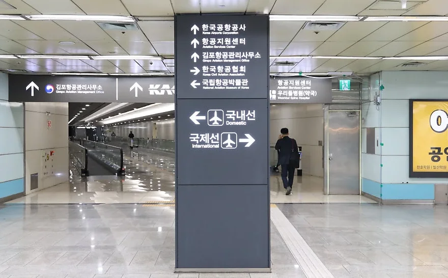 Wegweiser in Gimpo Airport Station: Inlandsterminal nach links, internationales Terminal nach rechts