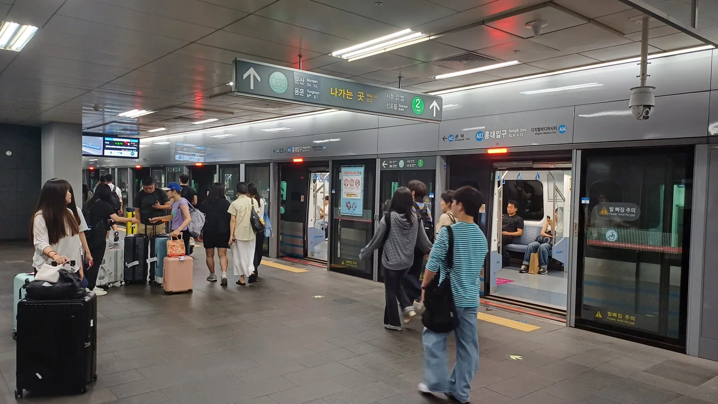 AREX-Bahnsteig Hongik University mit Umsteigeschildern zu Linie 2 und Gyeongui–Jungang