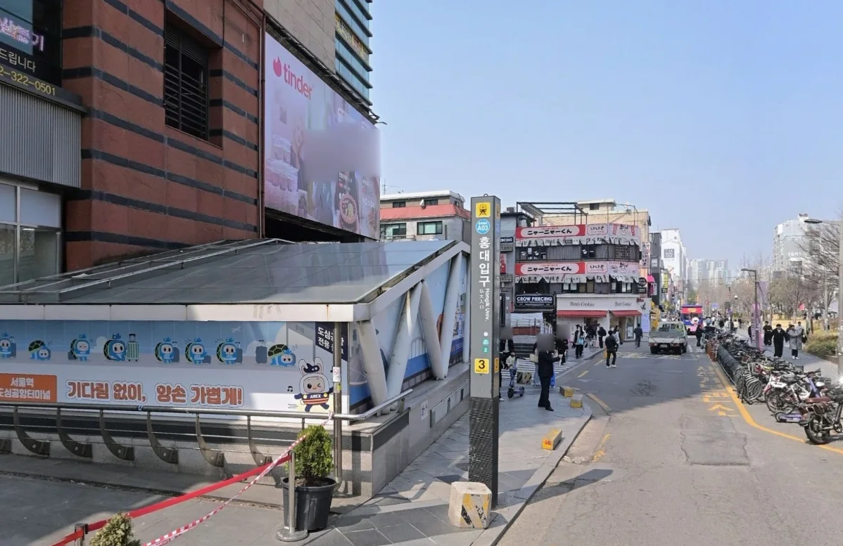 Eingang zu Ausgang 3 der Station Hongik University mit Stationsnamen und Ausgangsschild