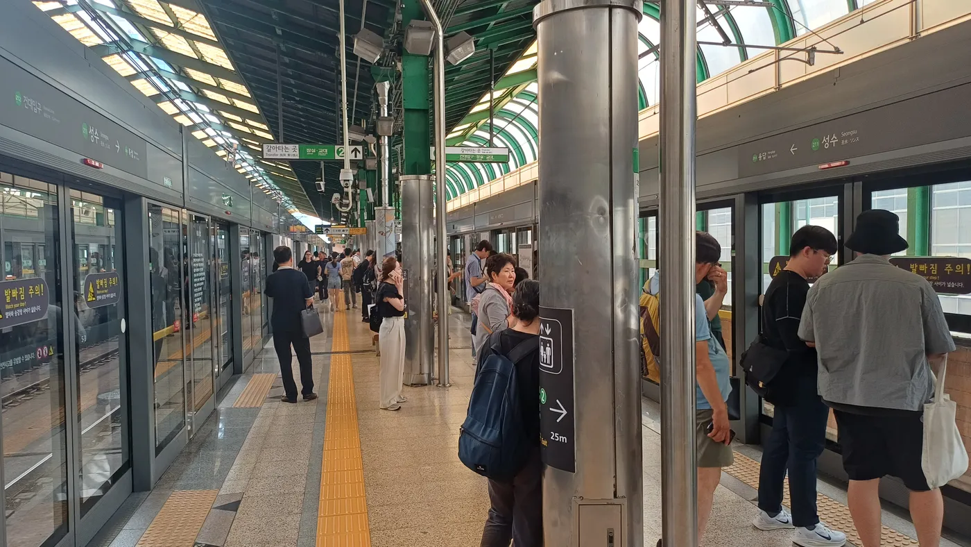 屋根のある聖水駅2号線の高架ホームと駅の案内表示