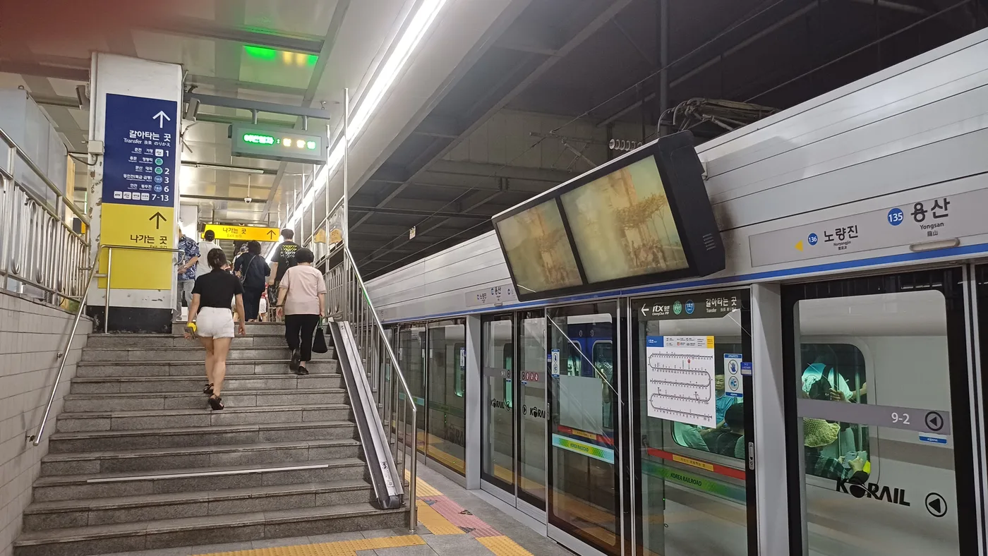 Bahnsteig der Linie 1 in Yongsan mit Treppe, Stationsschild und Umsteigehinweisen